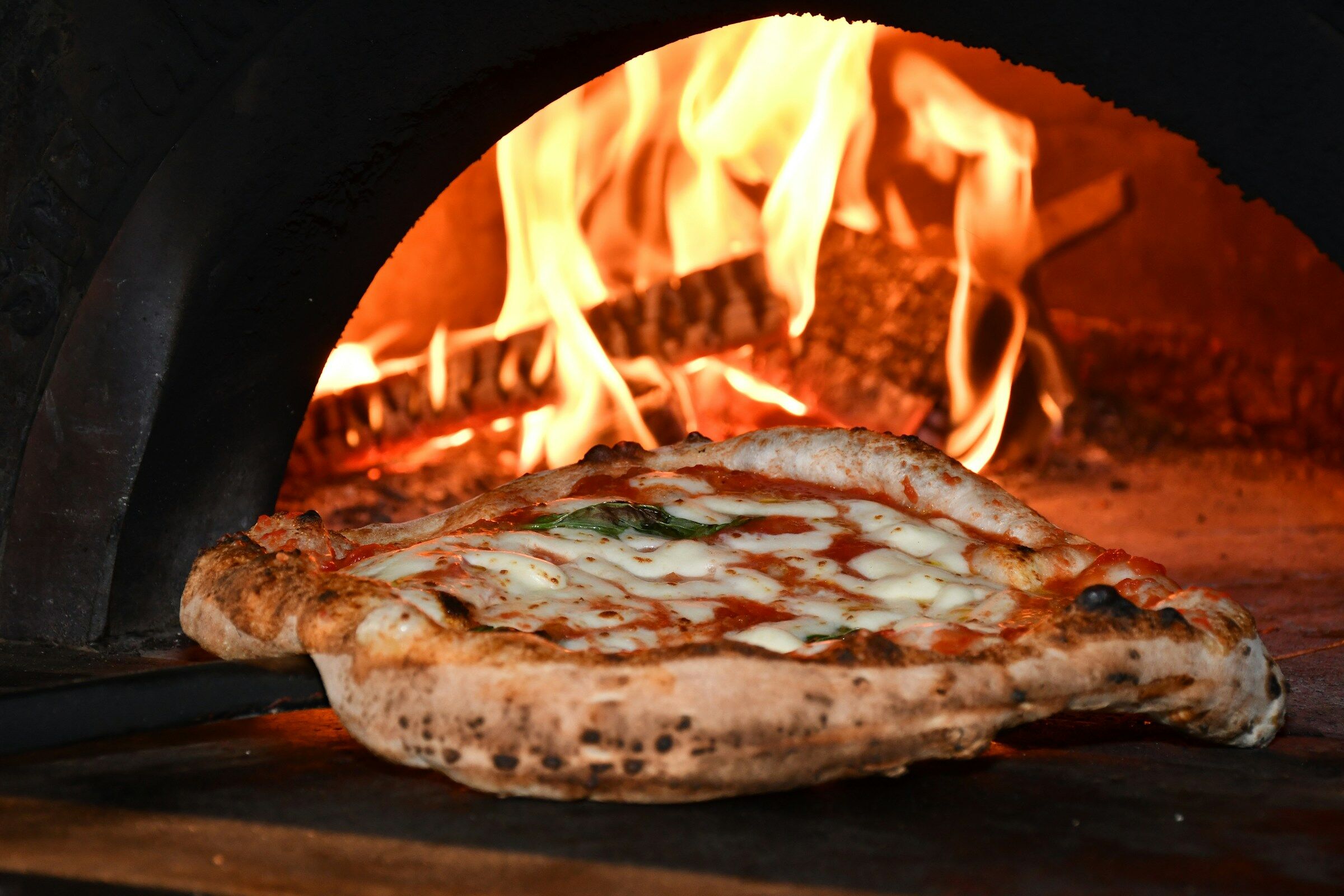 Nápolyi pizza a lobogó tűzű kemence előtt